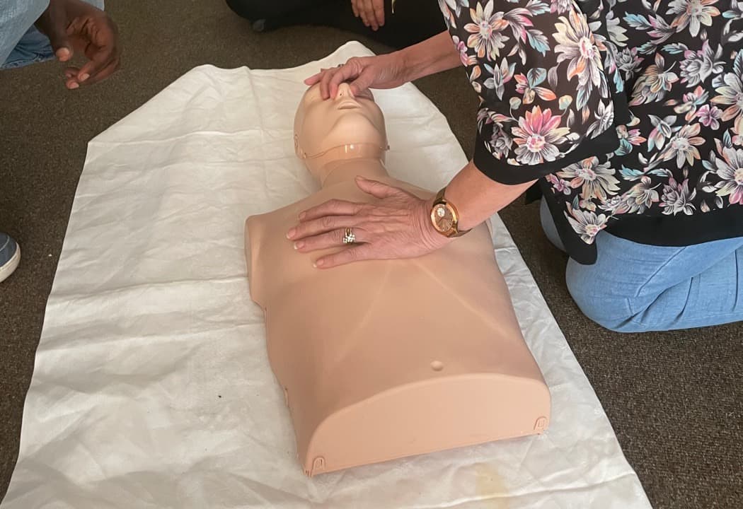 A delegate practising CPR on a training manikin